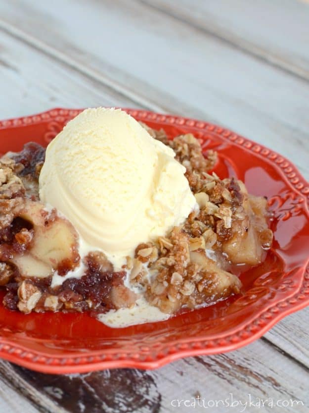 close up of apple fruit crisp with cranberries topped with vanilla ice cream