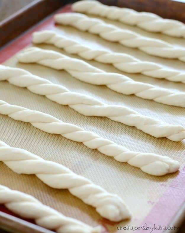 unbaked garlic cheddar breadstick twists on a cookie sheet