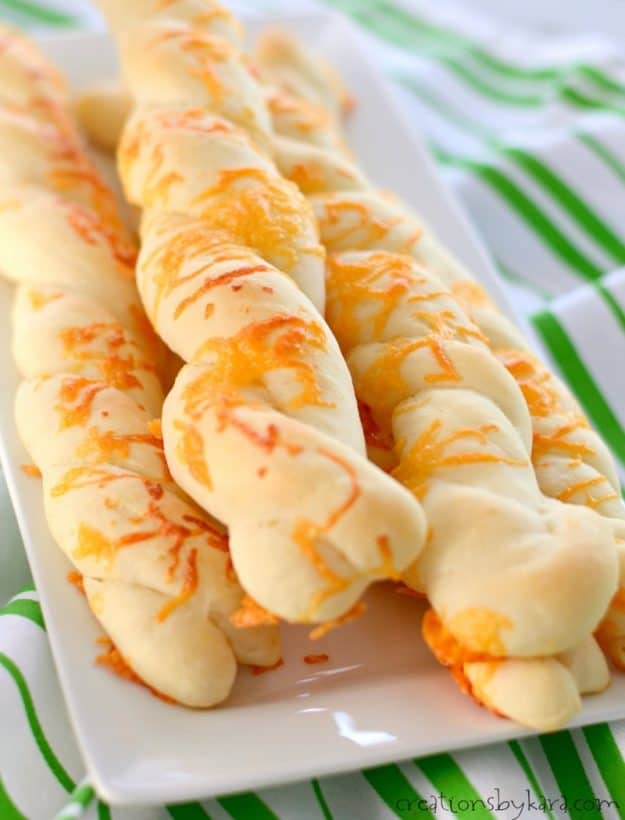 tray of cheddar breadstick twists on a striped dish towel
