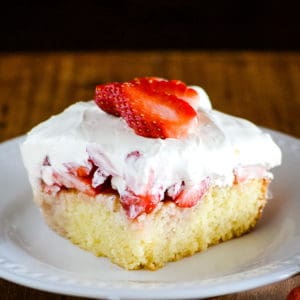 plate of yellow cake with strawberries and cream topping