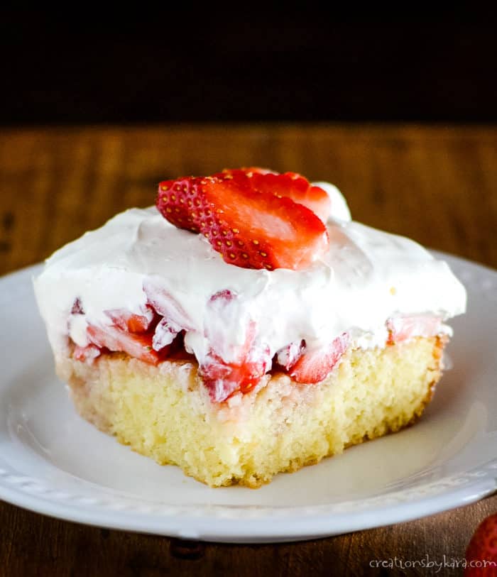plate of yellow cake with strawberries and cream topping