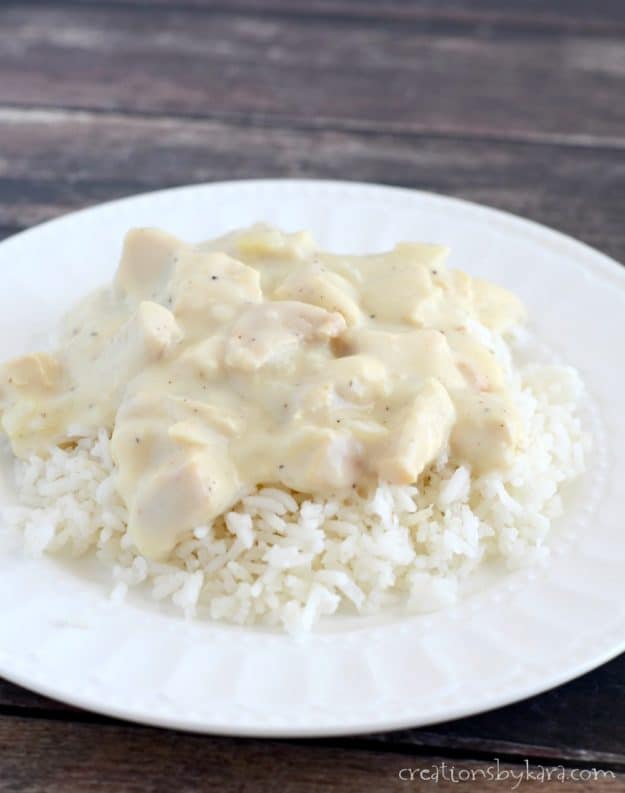 plate of white rice topped with chicken chunks in a creamy sauce
