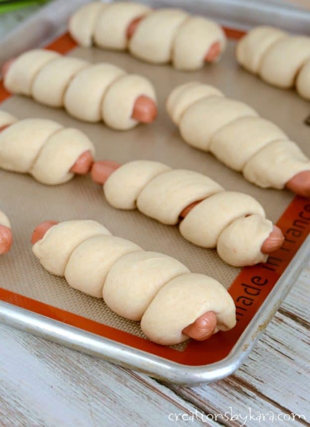 hot dogs wrapped in homemade dough on a cookie sheet