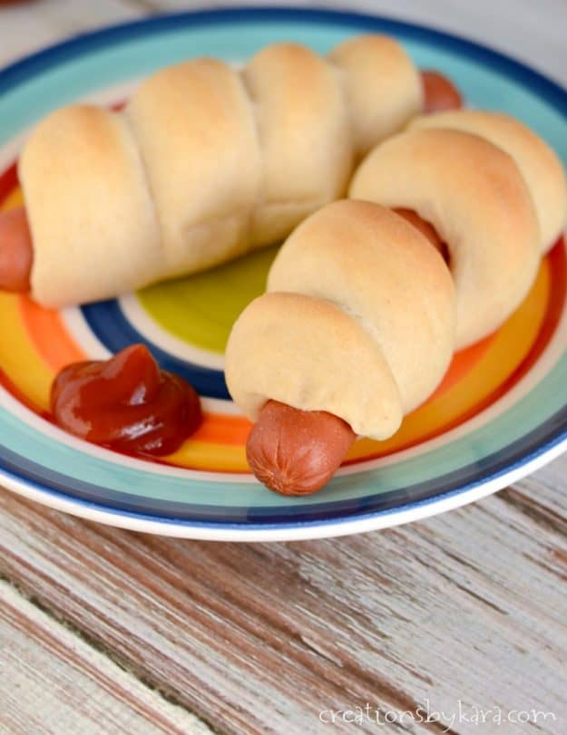 pigs in a blanket on a plate with ketchup