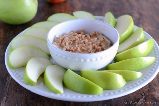 plate of apples with a bowl of fruit dip