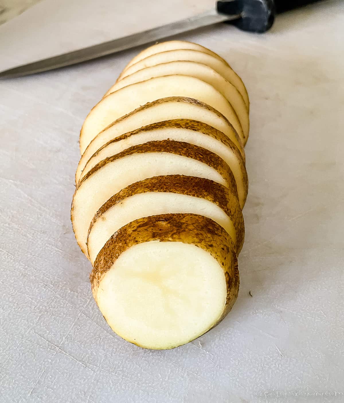 sliced russet potato on a cutting board