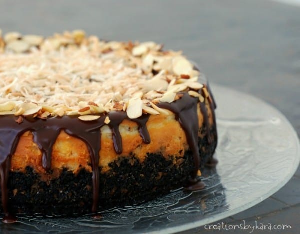 close up of almond coconut cheesecake with chocolate ganache, toasted coconut, and sliced almonds
