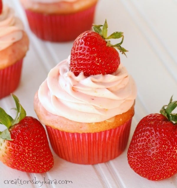 frosted strawberry cupcake with strawberries