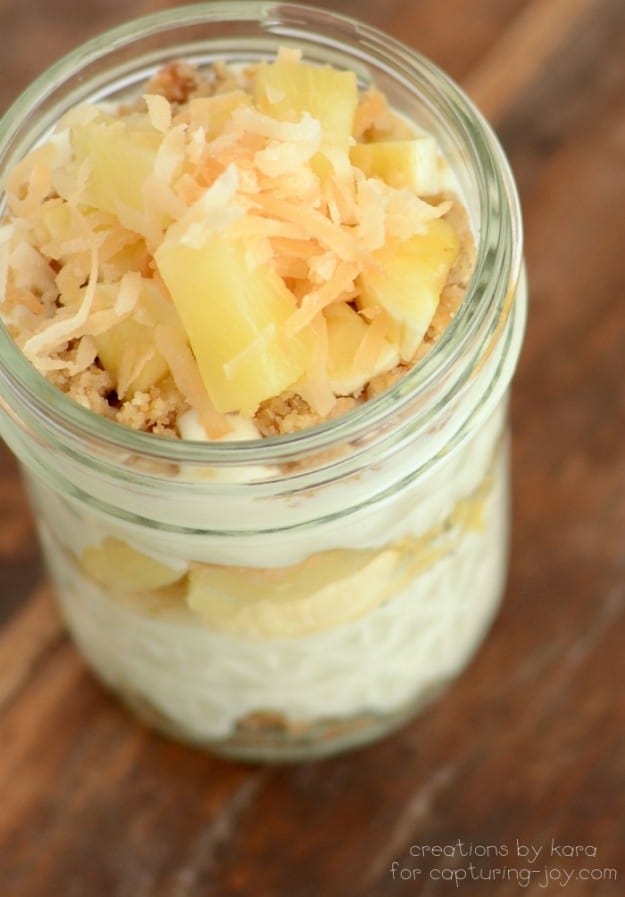 overhead shot of trifle in a mason jar topped with pineapple chunks and toasted coconut