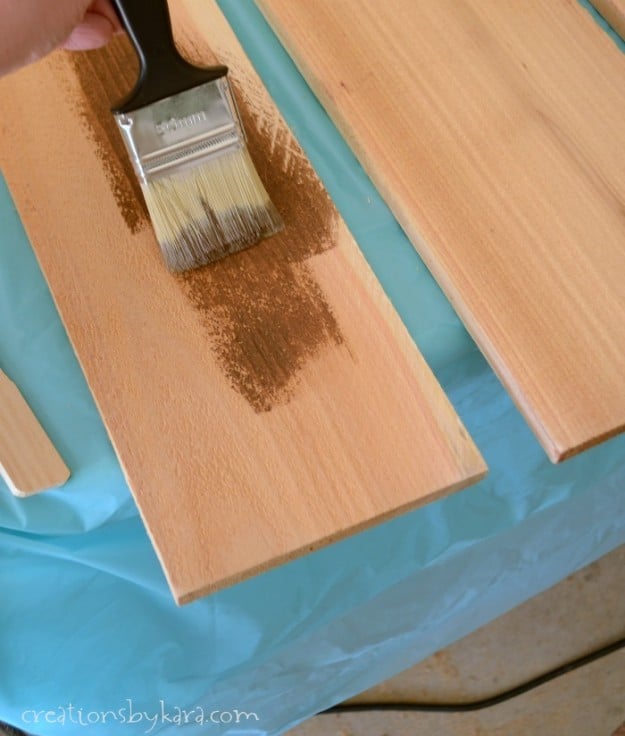 applying stain to a board with a brush