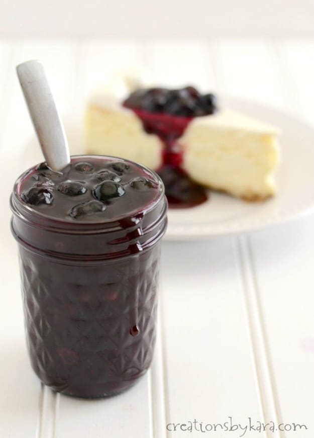 mason jar filled with blueberry sauce, with a spoon in it