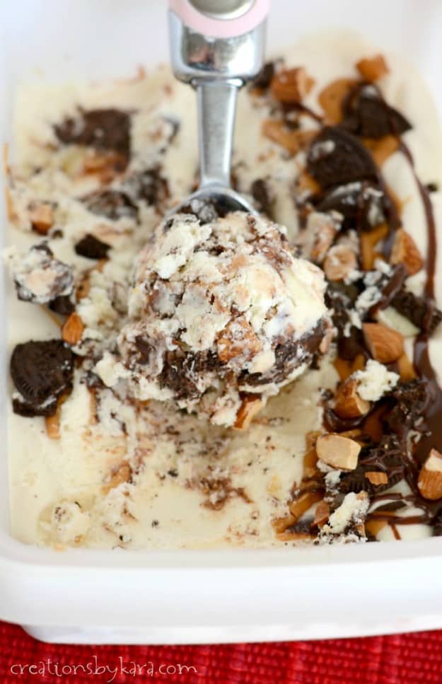 container of ice cream with oreos, nuts, peanut butter, and chocolate sauce