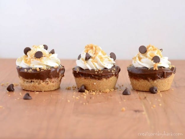 three frozen smore cups with mini chocolate chips and graham cracker crumbs
