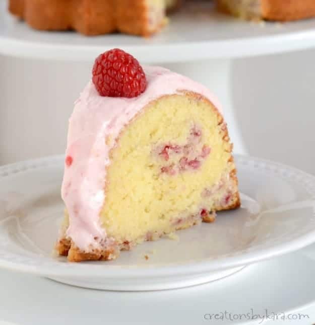 close up of slice of raspberry bundt cake with fresh raspberries