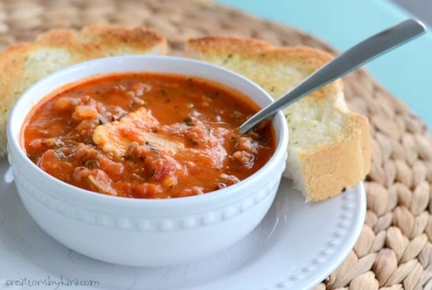 bowl of italian ravioli soup with garlic bread