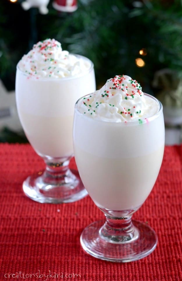 white punch in glasses topped with whipped cream and sprinkles