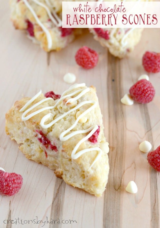 white chocolate raspberry scones with fresh raspberries on a cutting board