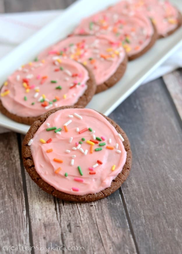 tray of chocolate cookies with pink buttercream frosting