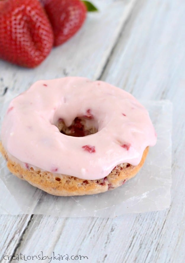 donut on waxed paper with strawberries in the background