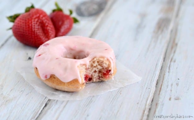 strawberry donut with a bite taken out of it