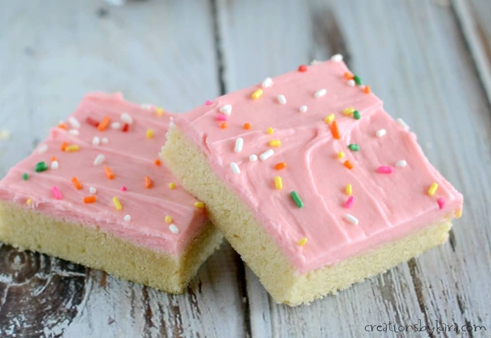 close up of sugar cookie bars with cream cheese frosting and sprinkles