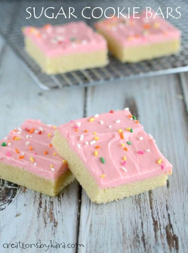 squares of sugar cookie bars with pink cream cheese frosting and sprinkles