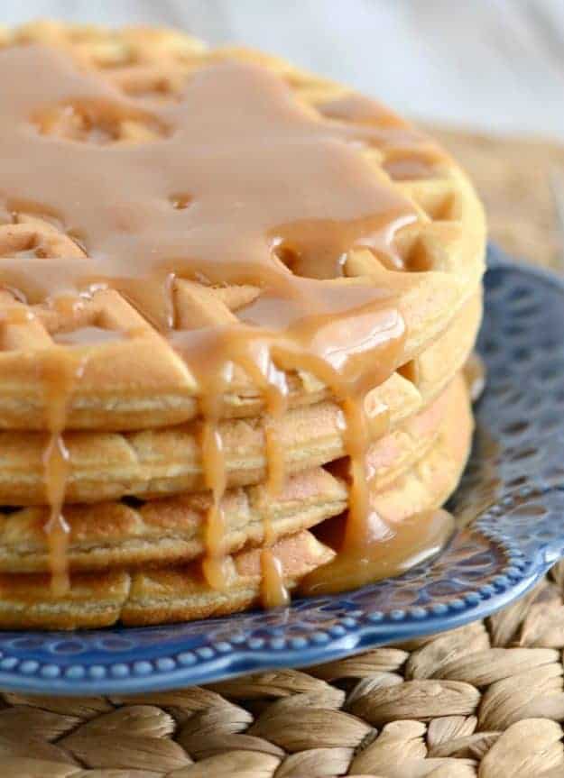 close up of peanut butter syrup dripping down the side of waffles