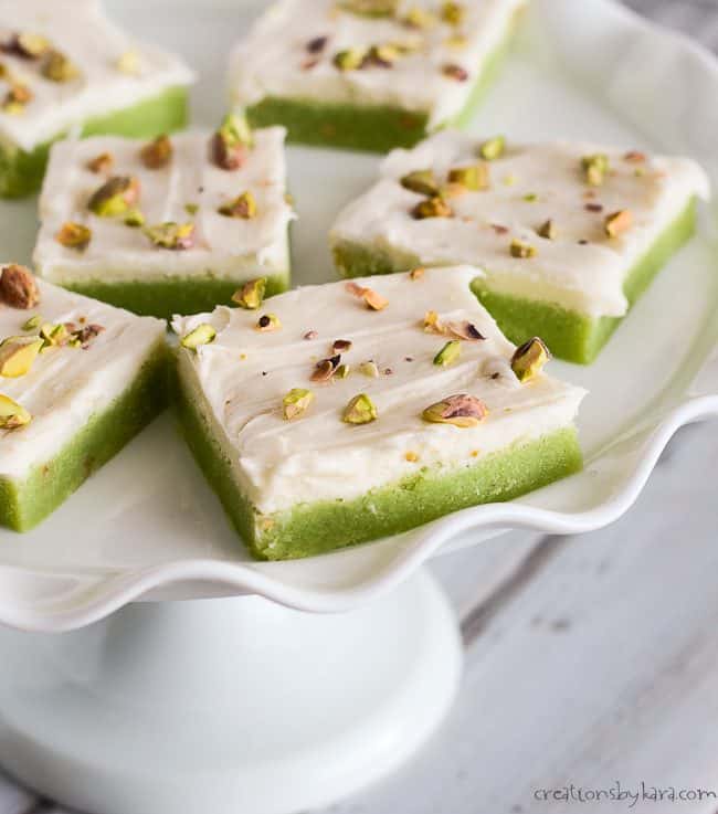 pistachio sugar cookie bars on a cake stand