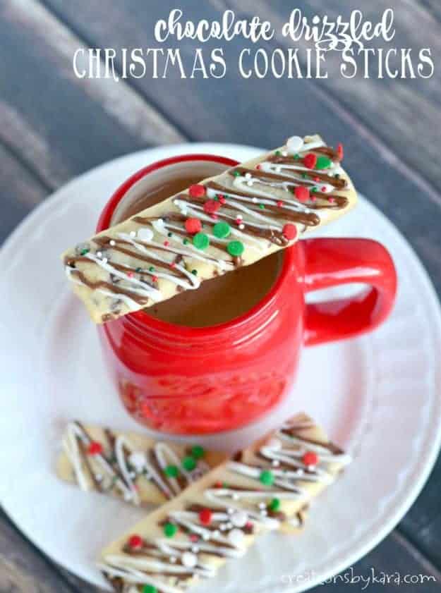 Chocolate Drizzled Christmas Cookie Sticks on a plate with a mug of hot cocoa
