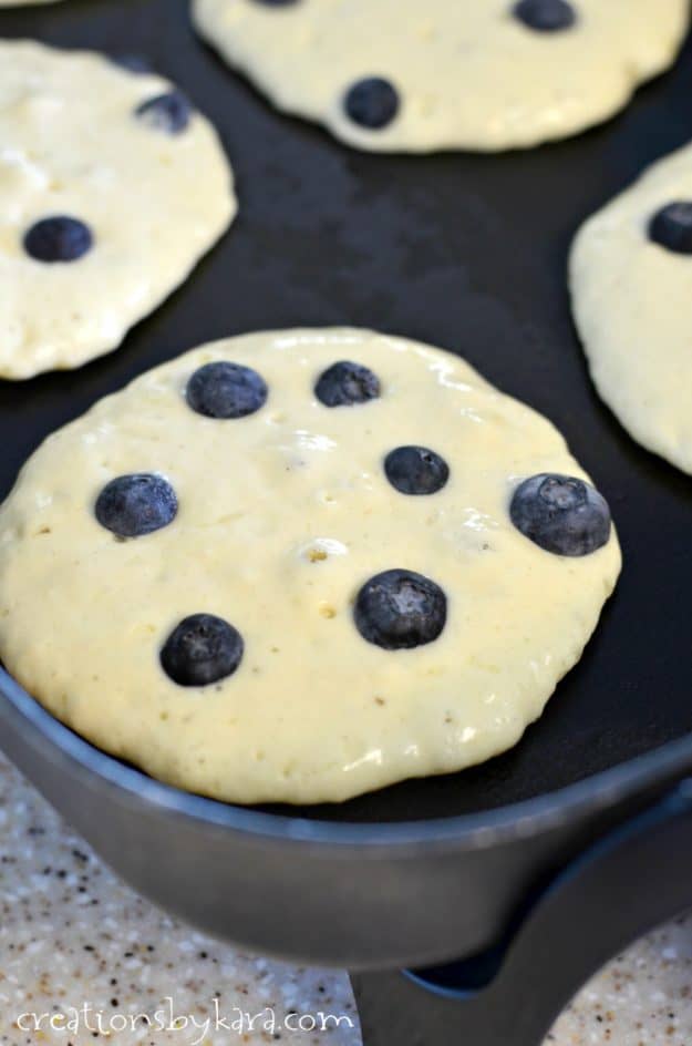 Adding blueberries to blueberry pancakes