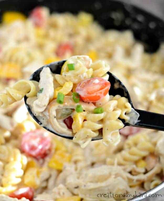 spoonful of pasta with chicken, sauce, and vegetables