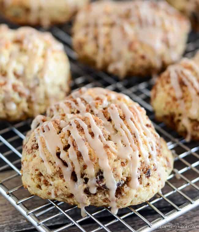 close up of cinnamon raisin biscuits with cinnamon glaze on a cooling rack
