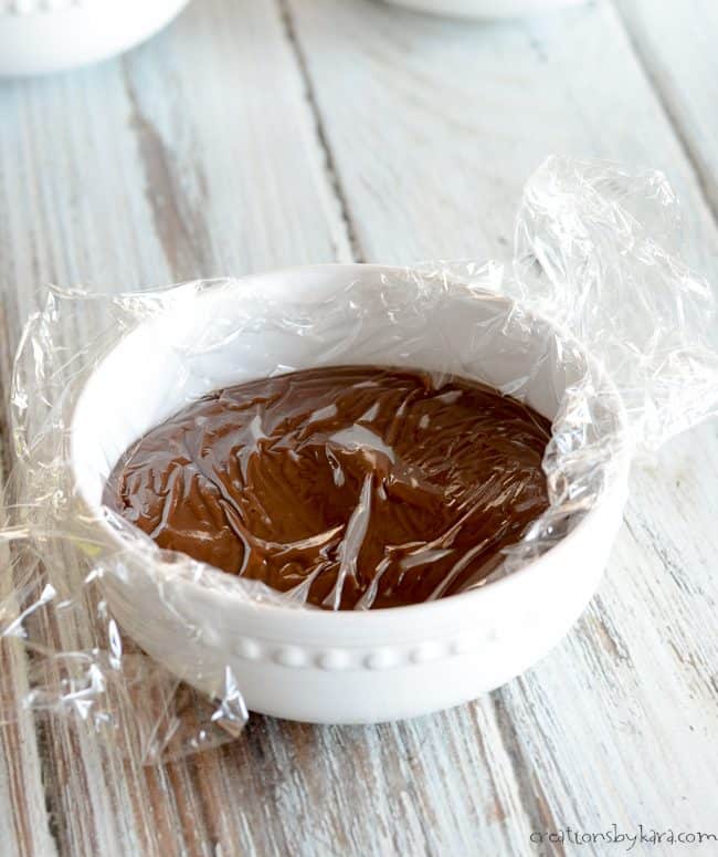 bowl of homemade pudding covered with plastic wrap
