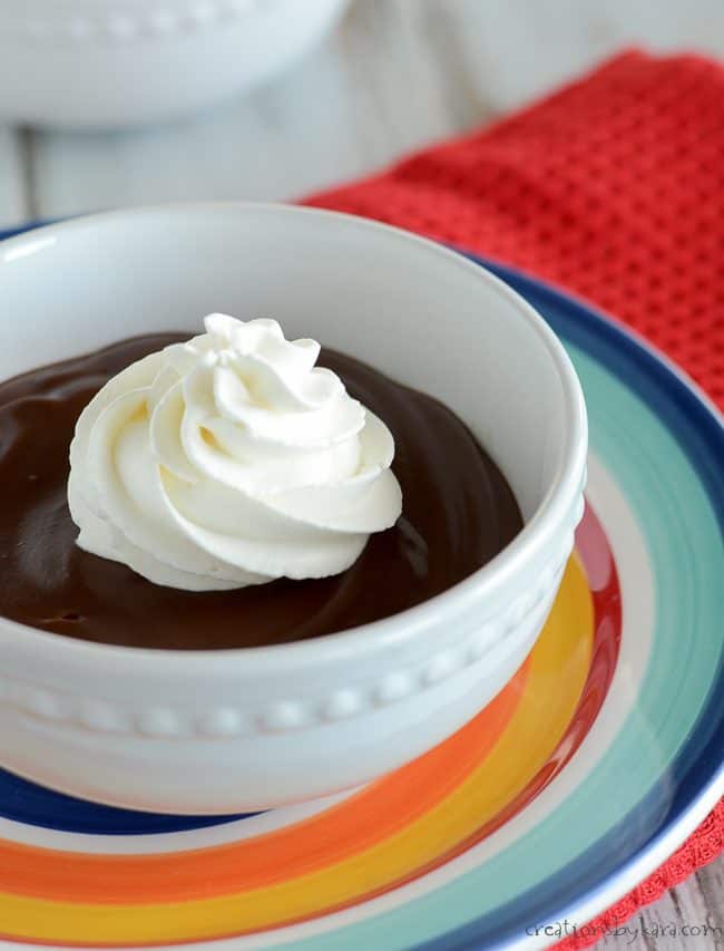 bowl of homemade chocolate pudding topped with fresh whipped cream 