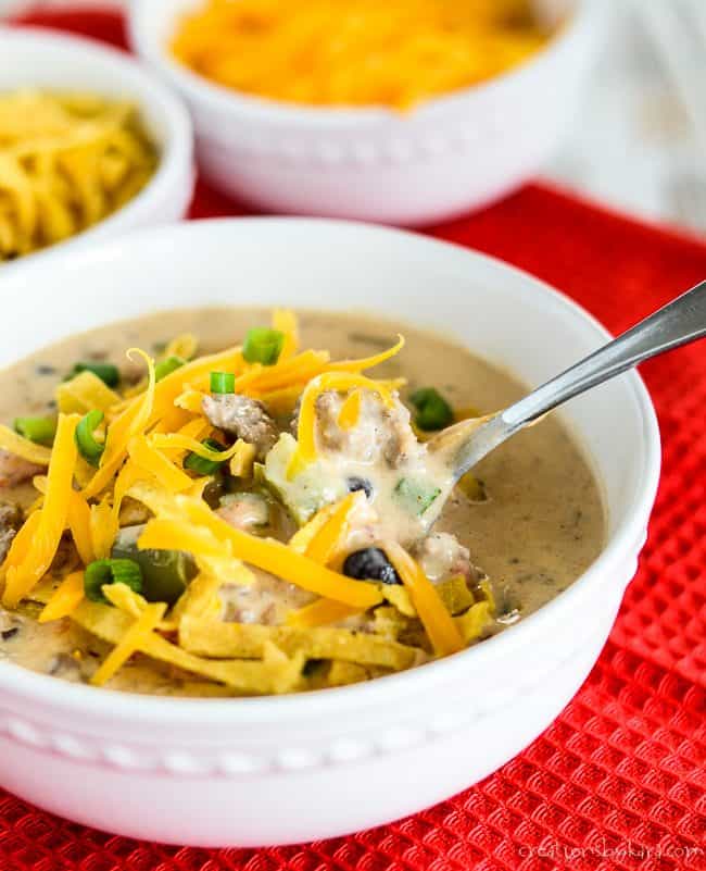 close up of a bowl of nacho soup with a spoon