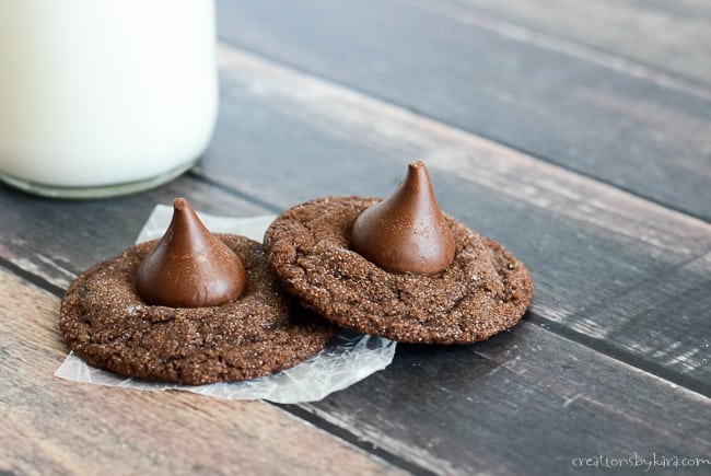 two chocolate kiss cookies with a glass of milk