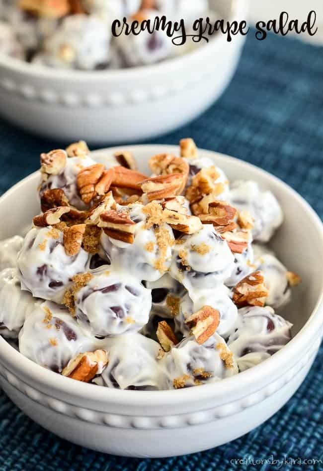 bowl of creamy grape salad topped with pecans and brown sugar