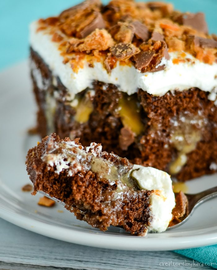 chocolate poke cake with caramel sauce, whipped cream, and butterfingers