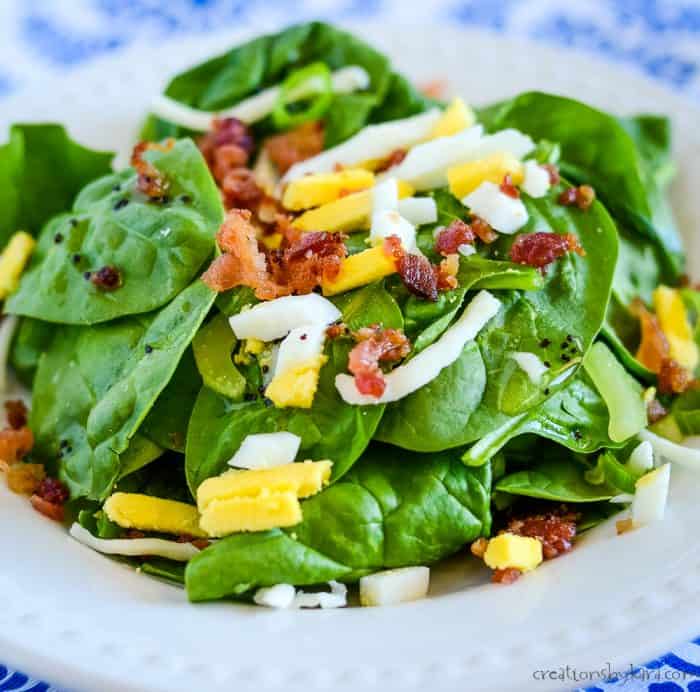 plate of spinach salad with toppings
