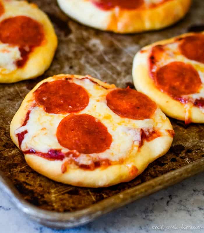 mini pizza with cheese and pepperoni on a cookie sheet