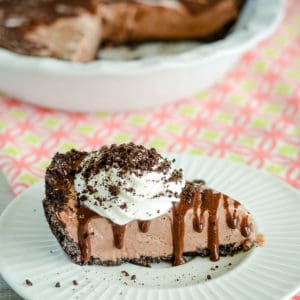 easy frozen mud pie on a plate with whipped cream and chocolate sauce