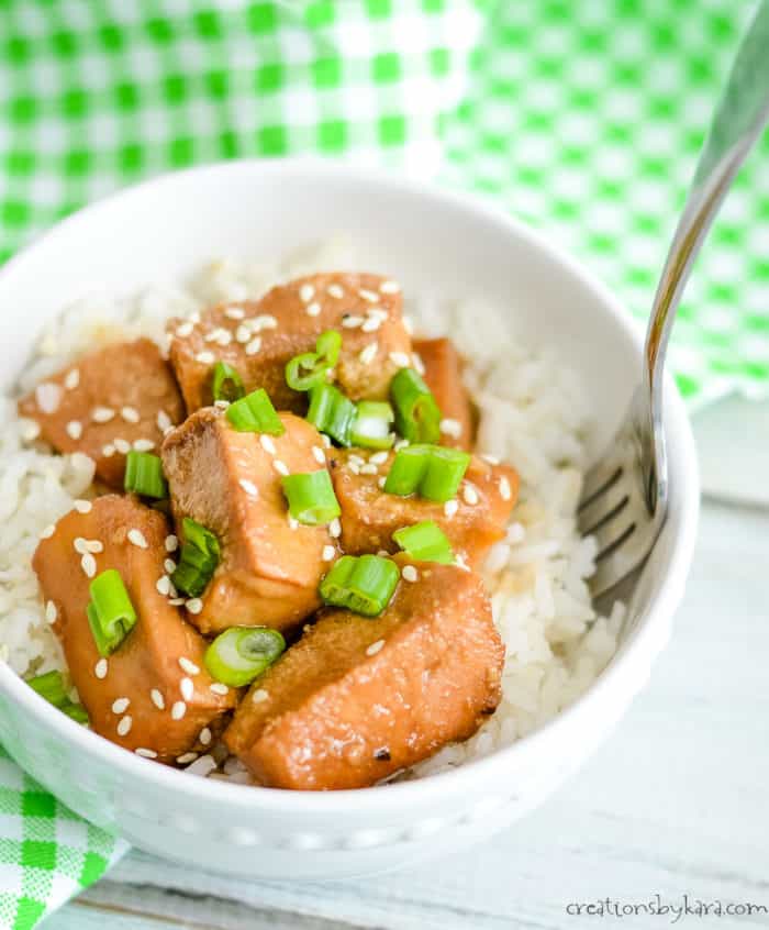bowl of rice and chicken with homemade teriyaki sauce, sesame seeds, and green onions