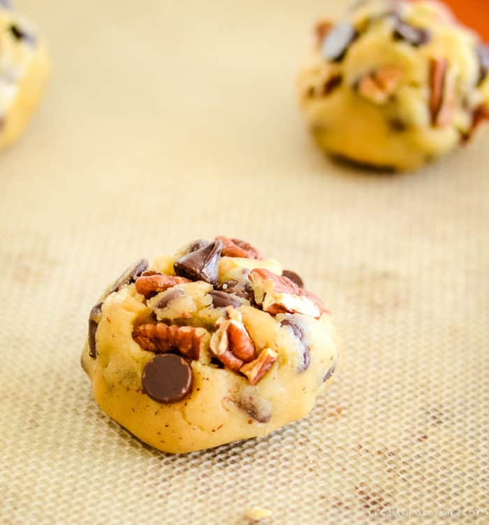 balls of cookie dough on a silicone lined cookie sheet