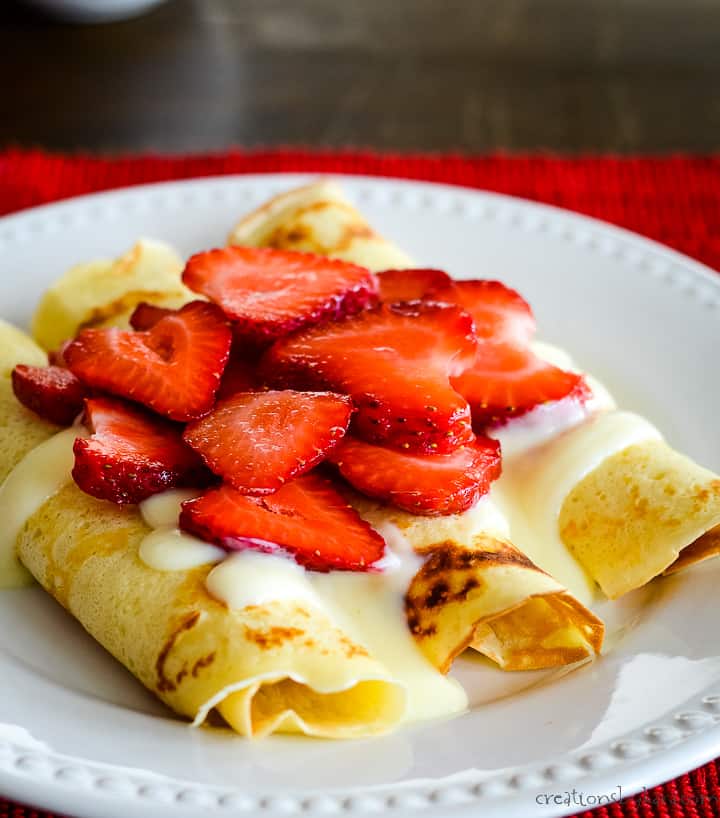 swedish pancakes topped with vanilla sauce and berries