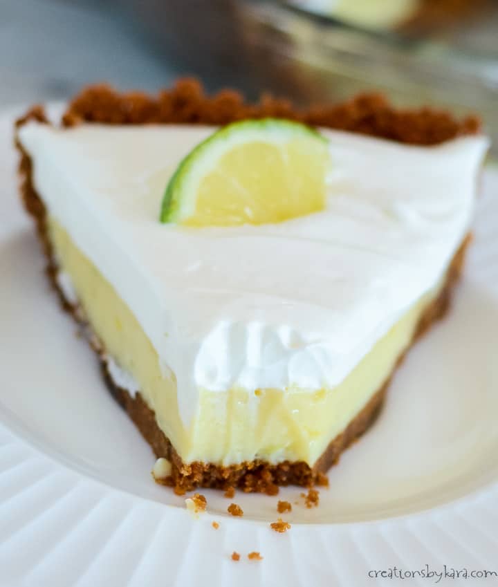 close up of a slice of key lime pie with whipped cream