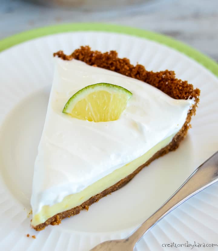 slice of key lime pie on a plate garnished with a lime wedge