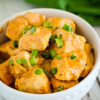 bowl of creamy paprika chicken garnished with green onions