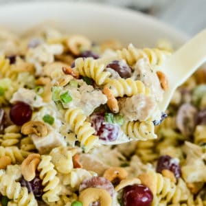 cold chicken pasta salad being scooped from a bowl