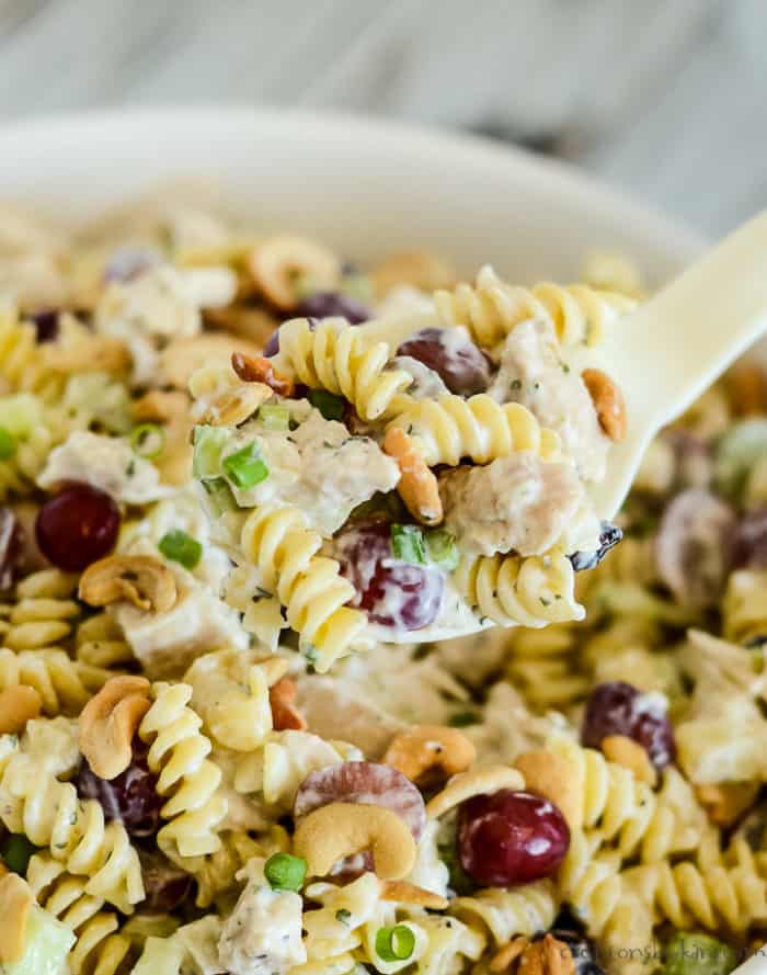 cold chicken pasta salad being scooped from a bowl