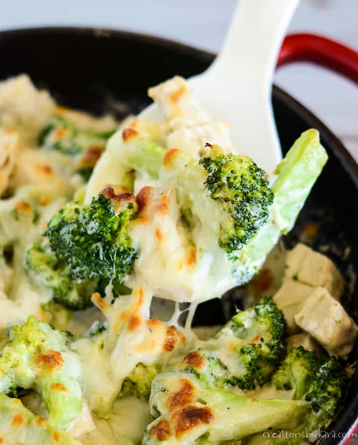 spoonful of keto chicken broccoli casserole being scooped from the skillet